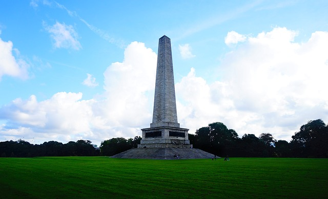 There is a large obelisk in the middle of a grassy field in phoenix park