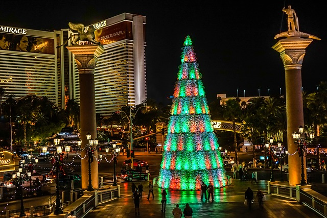 A large christmas tree is lit up in Las Vegas at night.