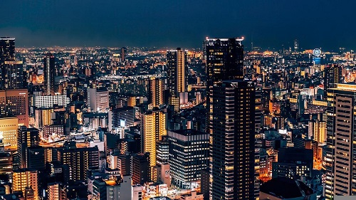 An aerial view of Osaka at night with lots of tall buildings