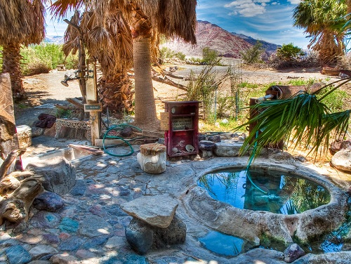 A hot tub surrounded by rocks and palm trees  in Death Valley National Park