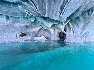 A cave filled with water and ice is surrounded by a body of water.