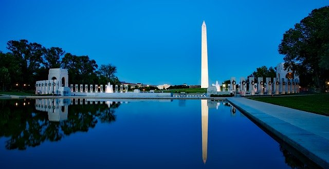 The washington monument is reflected in the water