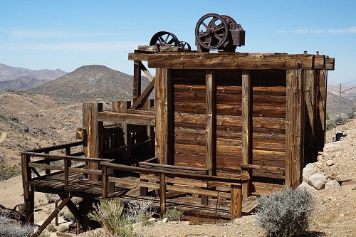 An old wooden building in Joshua Tree NP with mountains in the background