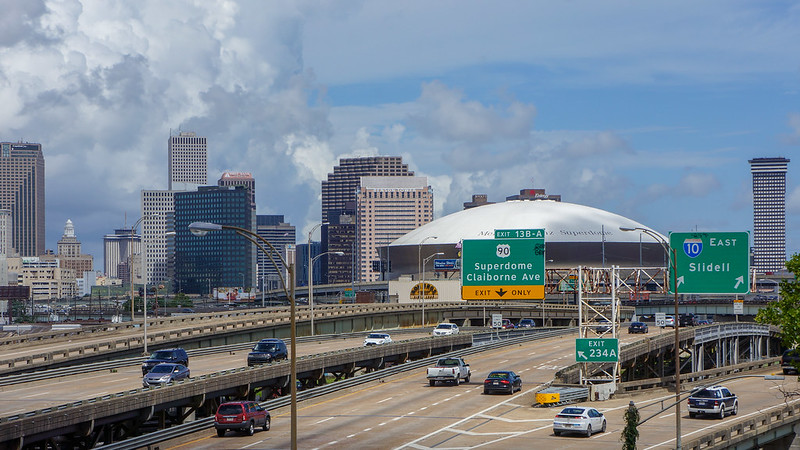 A highway going through a city with a dome in the background.