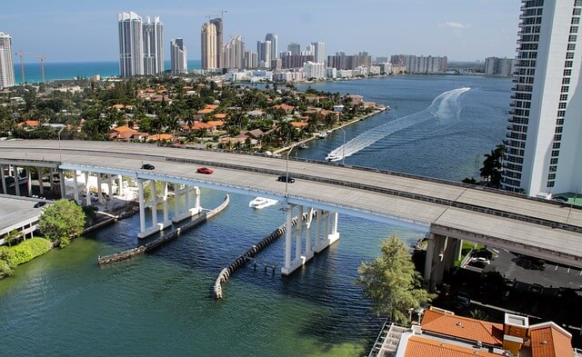 A bridge over a body of water with Miami in the background