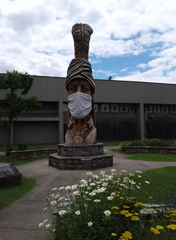 A statue of a man wearing a face mask in front of a building in Great Smoky Mountains NP