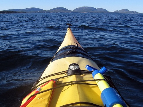 A yellow kayak is floating on top of a body of water in Acadia NP