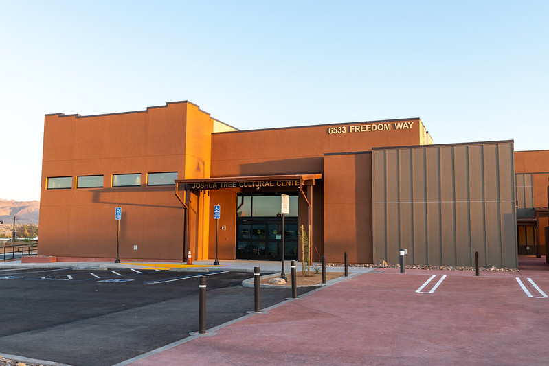 A large brown building with a parking lot in front of it near Joshua Tree NP.