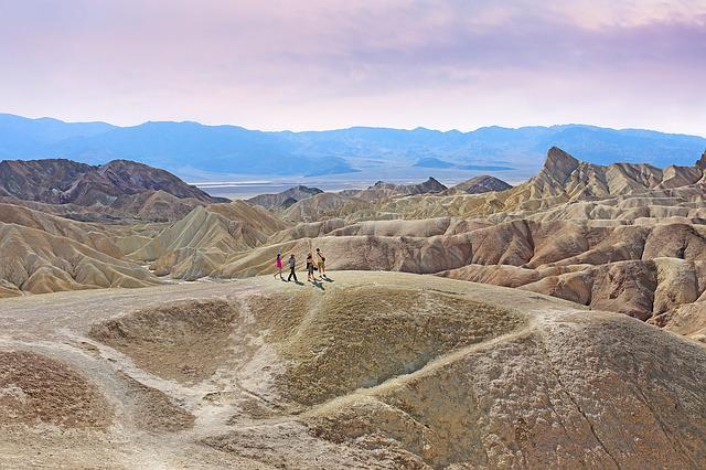 A group of people are standing on top of a hill  in Death Valley National Park