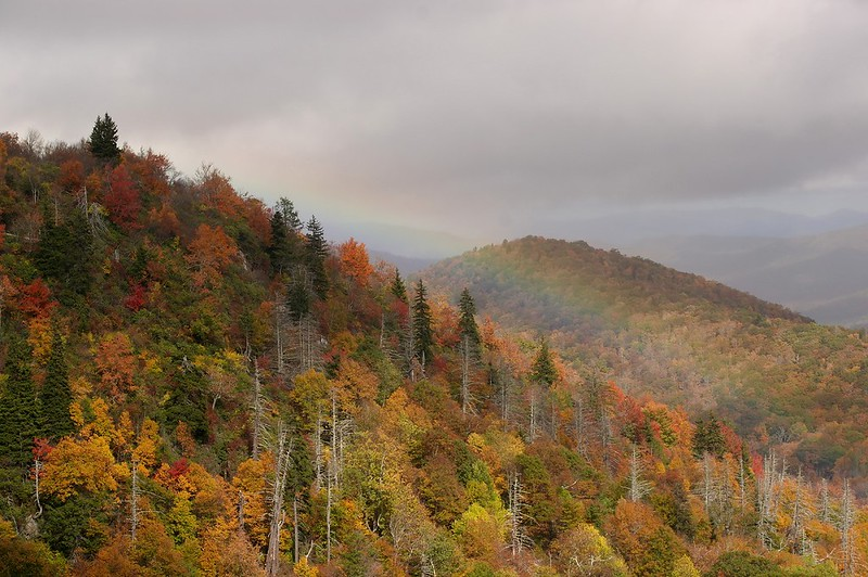 A rainbow is visible over the smoky mountains