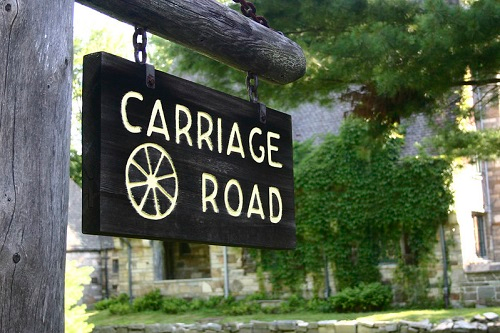 A carriage road sign hangs from a wooden post in Acadia NP