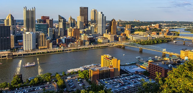 An aerial view of the Pittsburgh skyline with a river in the foreground.