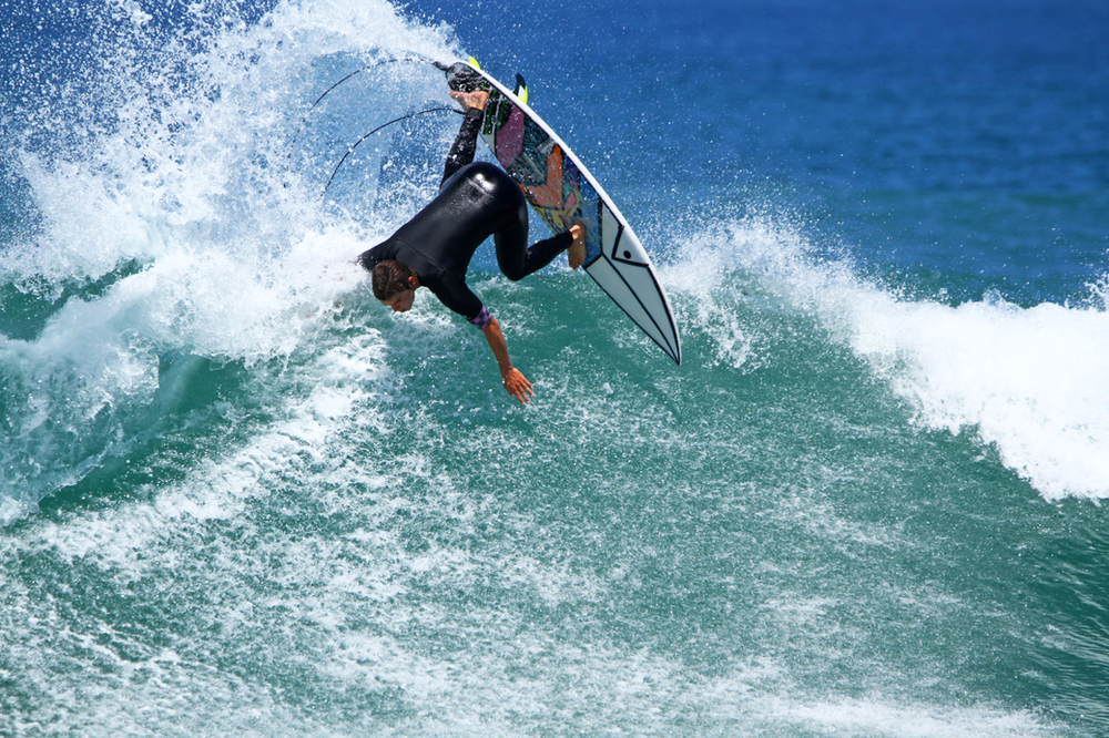 A man is riding a wave on a surfboard in the ocean at Zuma Beach