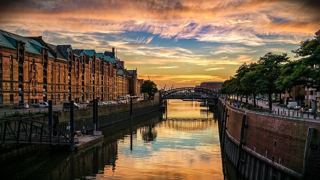 A river runs through Hamburg at sunset.