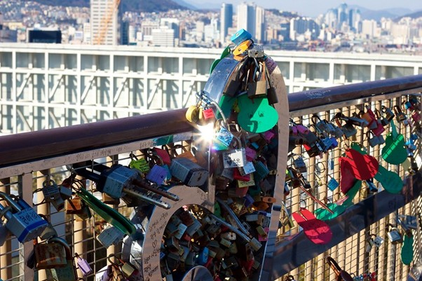 A bunch of locks are hanging on a bridge in Busan