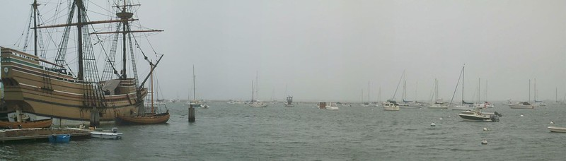 A group of sailboats are docked in a harbor on a cloudy day in Plymouth