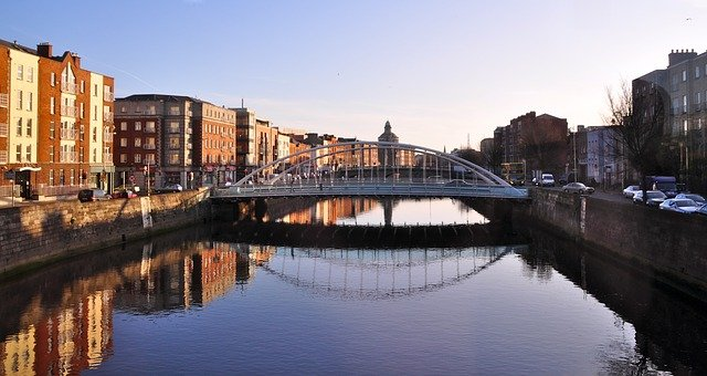 A bridge over a river in dublin with buildings in the background