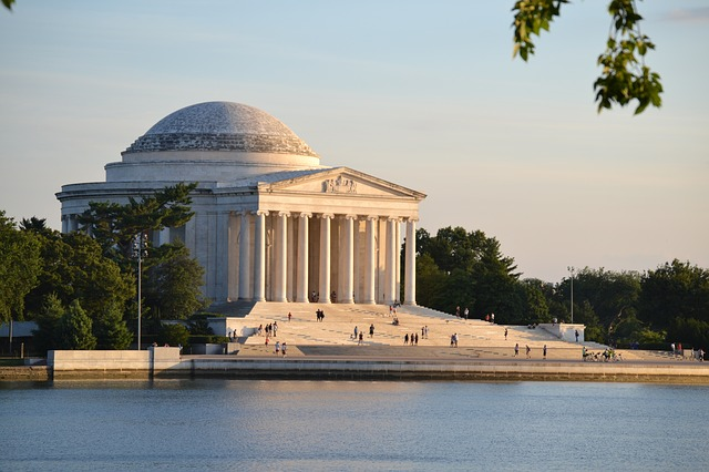 The washington monument is surrounded by water and trees in washington d.c.