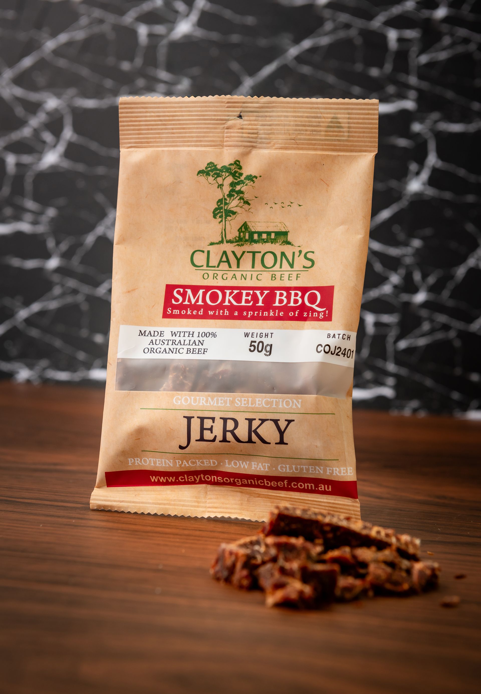 A bag of clayton 's smokey bbq jerky on a wooden table