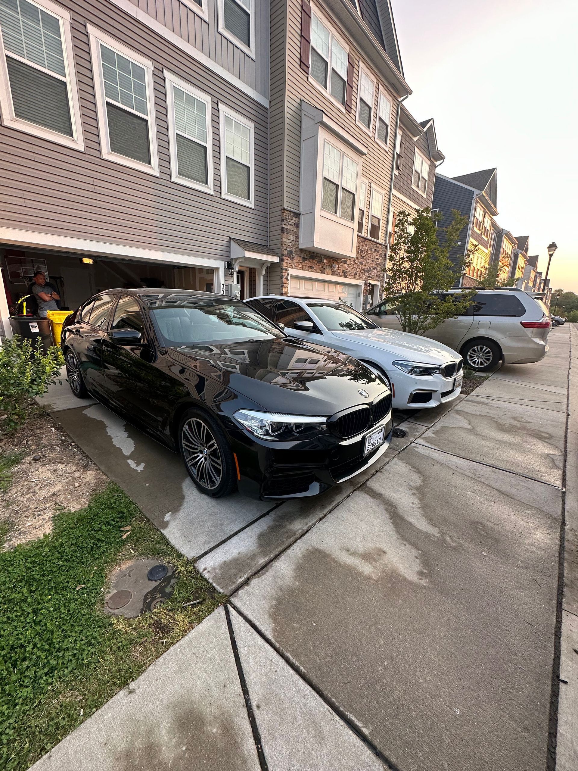 Three cars are parked on the side of the road in front of a building.