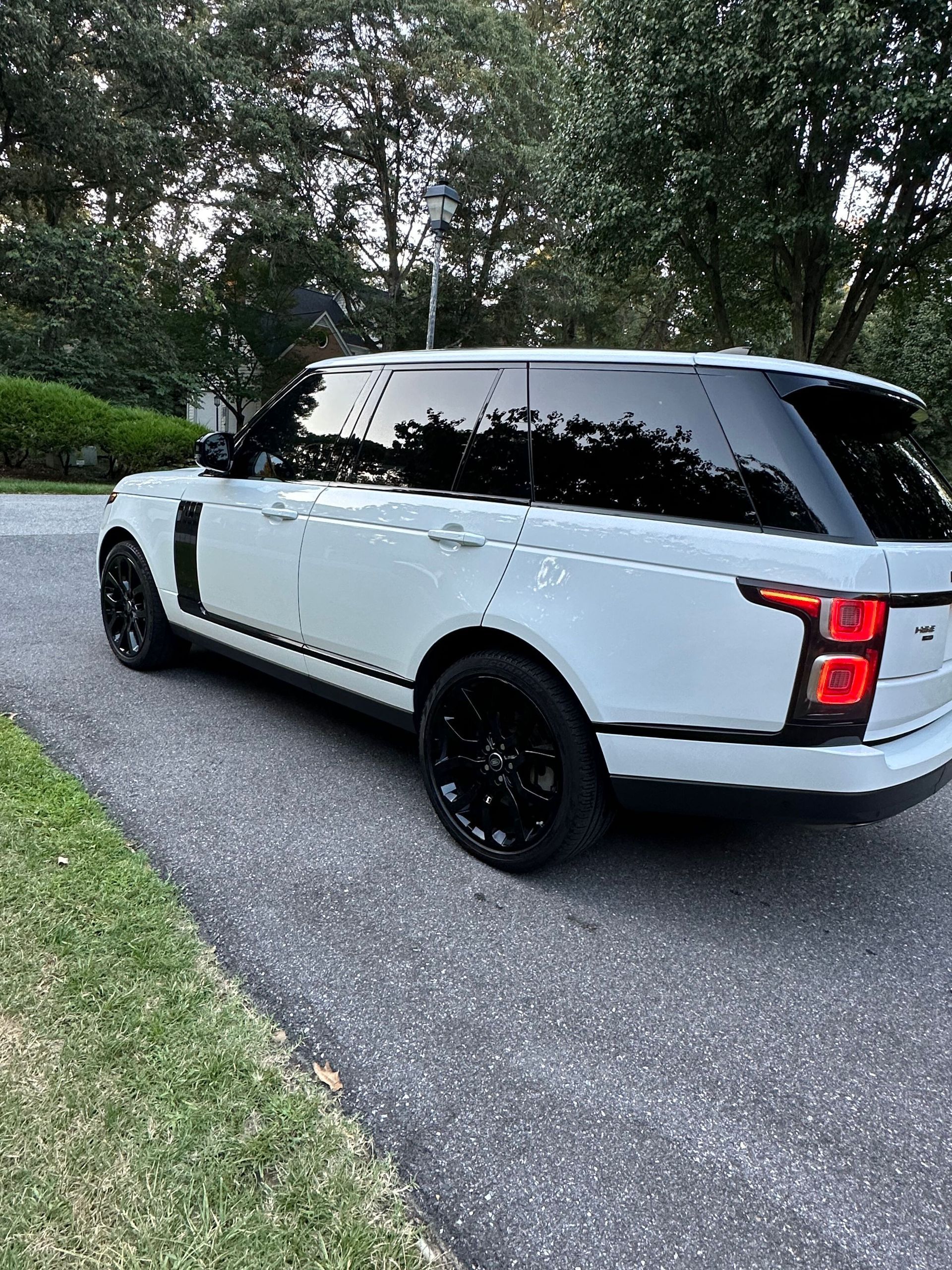 A white range rover is parked on the side of the road.