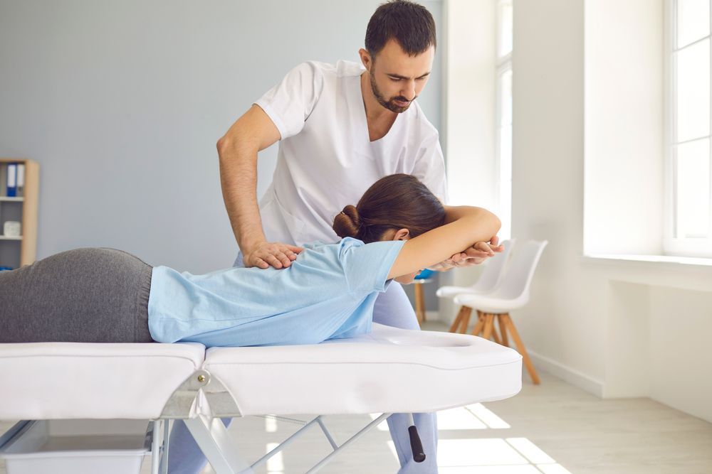 Therapist Adjusting a Child’s Back on a Treatment — Back Care Gold Coast In Southport, QLD