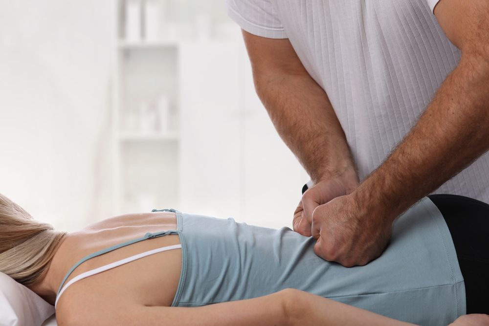 A Man is Giving a Woman a Massage on Her Back — Back Care Gold Coast In Nerang, QLD