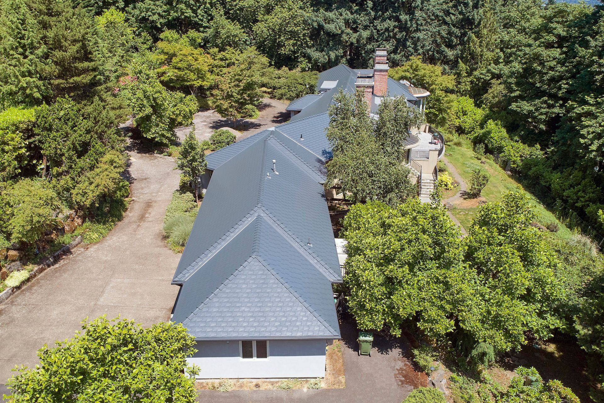 Overhead perspective of a complex roof system with multiple ridges and valleys clad in Deep Charcoal Interlock Slate aluminum roofing. Installed in Portland’s Dunthorpe neighborhood, this project demonstrates precision craftsmanship and enhanced storm resilience.