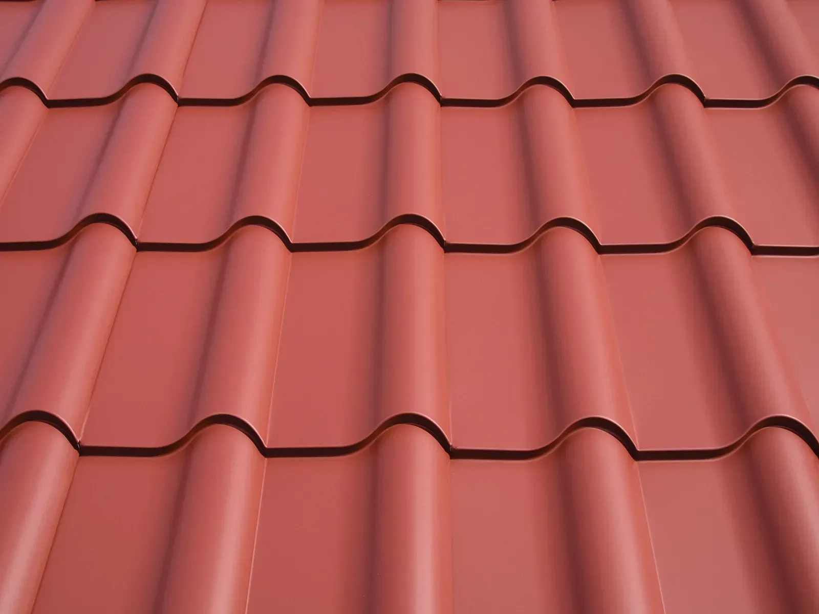 Interlock Mediterranean Tile aluminum metal roof panels in terracotta red, close-up, Portland, Oregon.