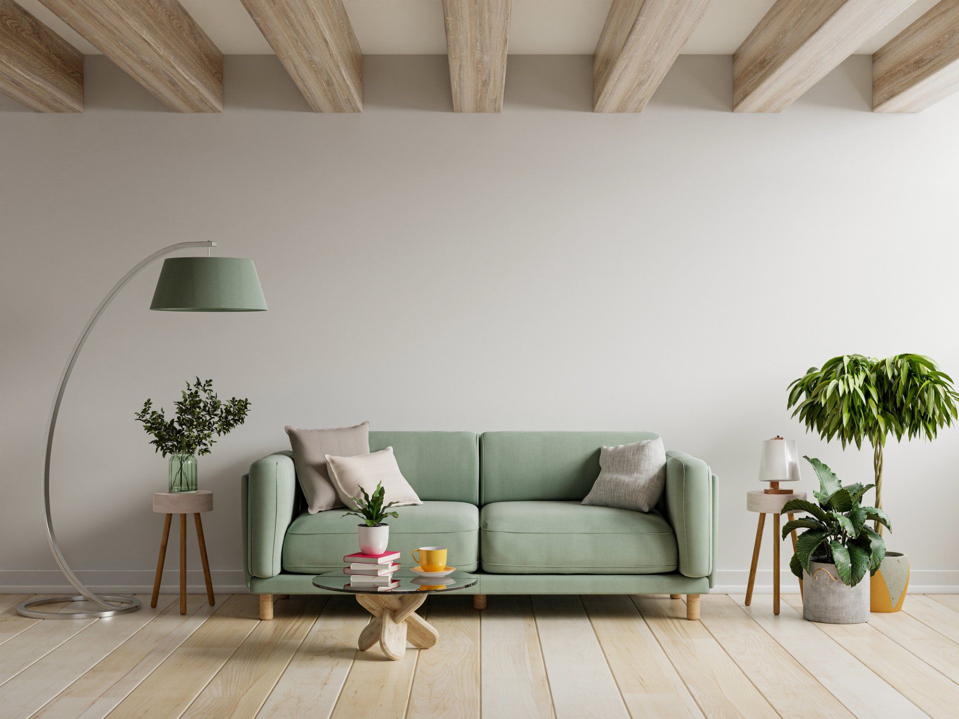 A living room with a green couch , coffee table , lamp and plants.