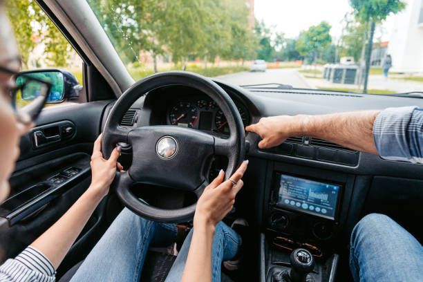 A man and a woman are driving a car.
