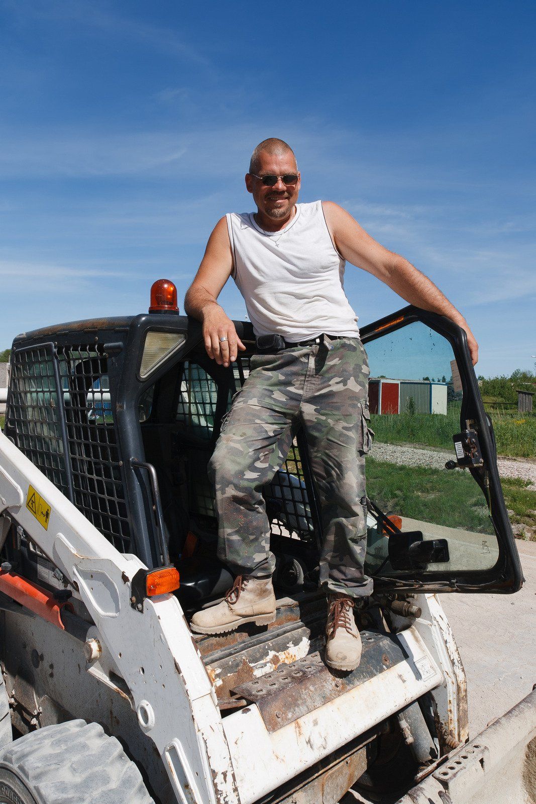 Steer Bobcat employee standing on bobcat