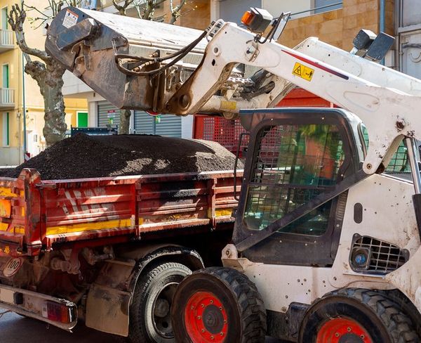 Bobcat dumping asphalt for Steer Bobcat picture