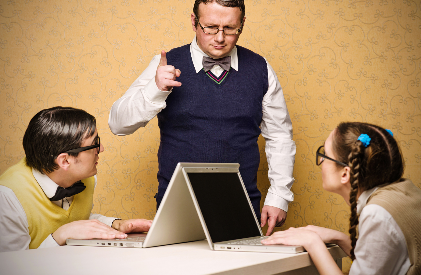 Vintage picture of parent pointing his finger at adult children with computers