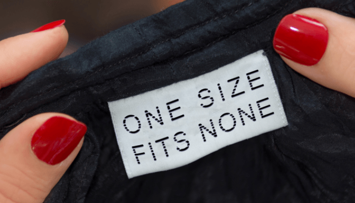 closeup of manicured hands looking at a garment label - one size fits none