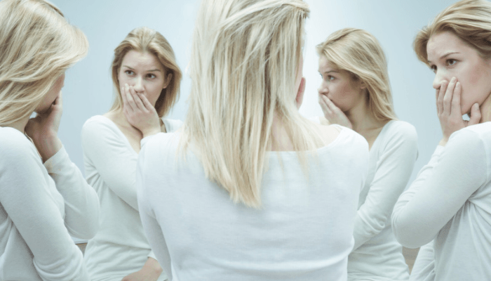 woman looking  at herself in a five-way mirror