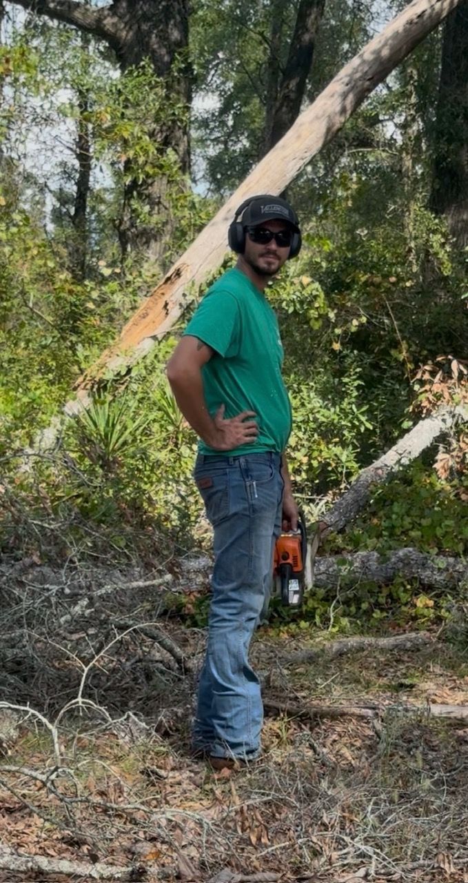 Kelly's RV Park. White building with sign in front of a treeline. Green field in foreground.