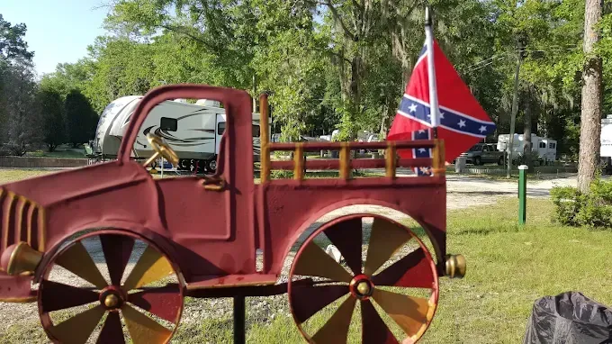 Red metal truck decoration with Confederate flag in a campground.