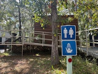Sign for public restrooms with shower symbols; accessible ramp.