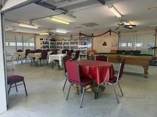 Garage converted into a social space with tables, chairs, and a pool table.
