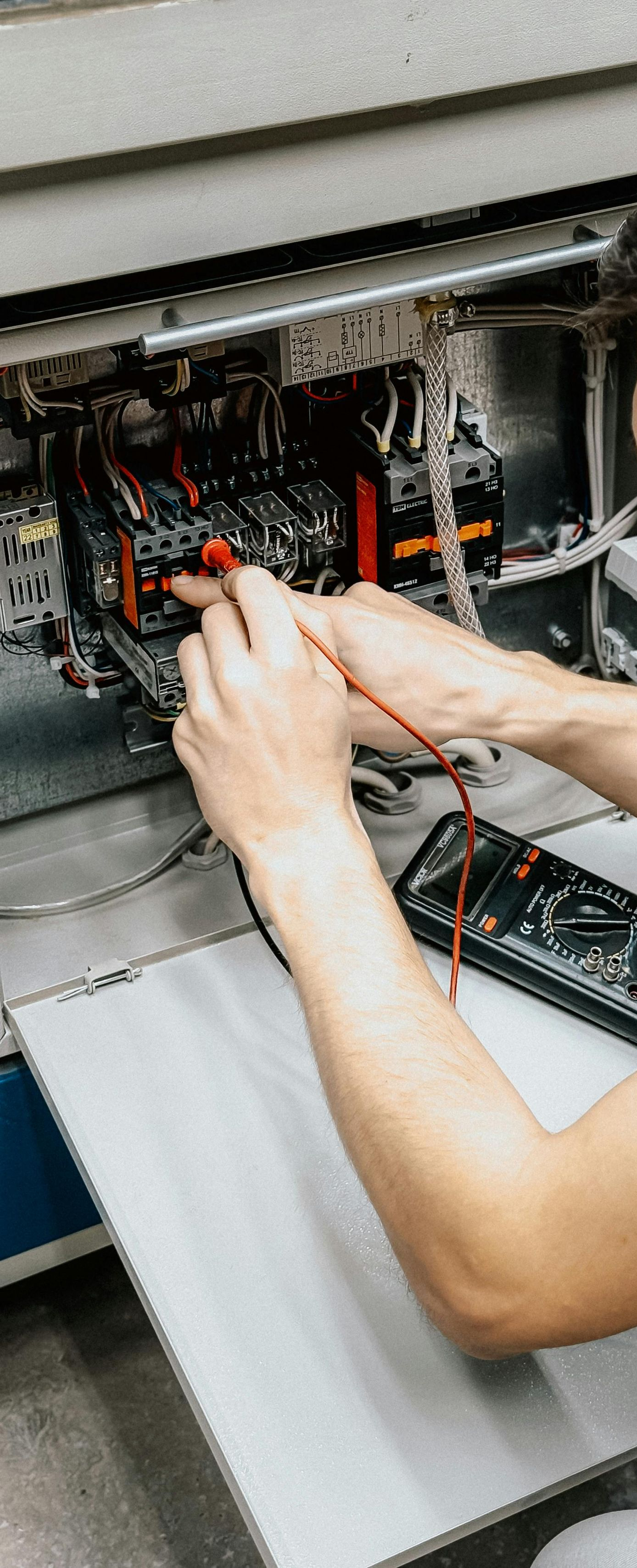 Person Kneeling, Holding Coiled Cable, Illuminating Cabinet — Do Right Electrical in Redlynch, QLD