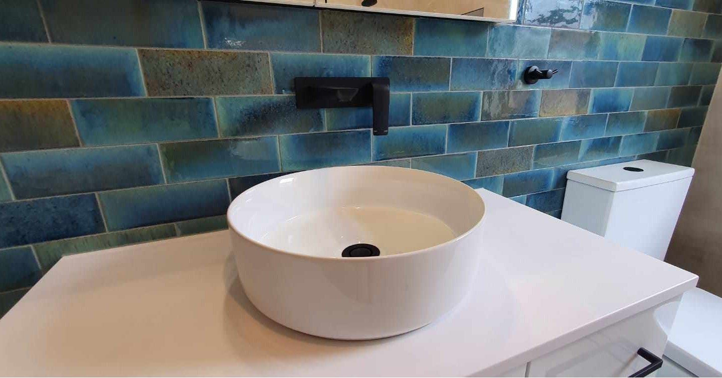 A bathroom with a round sink and a toilet.