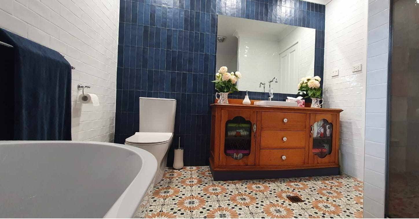 A bathroom with a bathtub, toilet, sink and mirror.