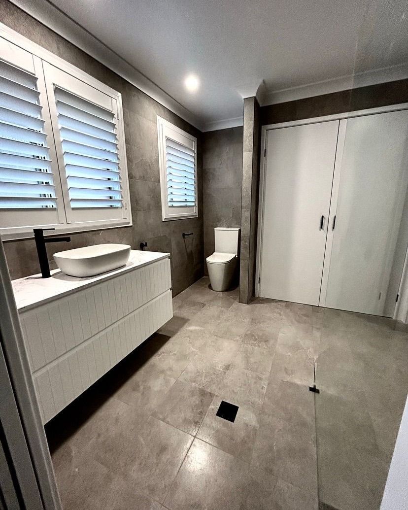 A bathroom with a sink, toilet and window