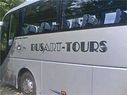 Ein Bus mit der Aufschrift „Busart-Tours“ auf der Seite.