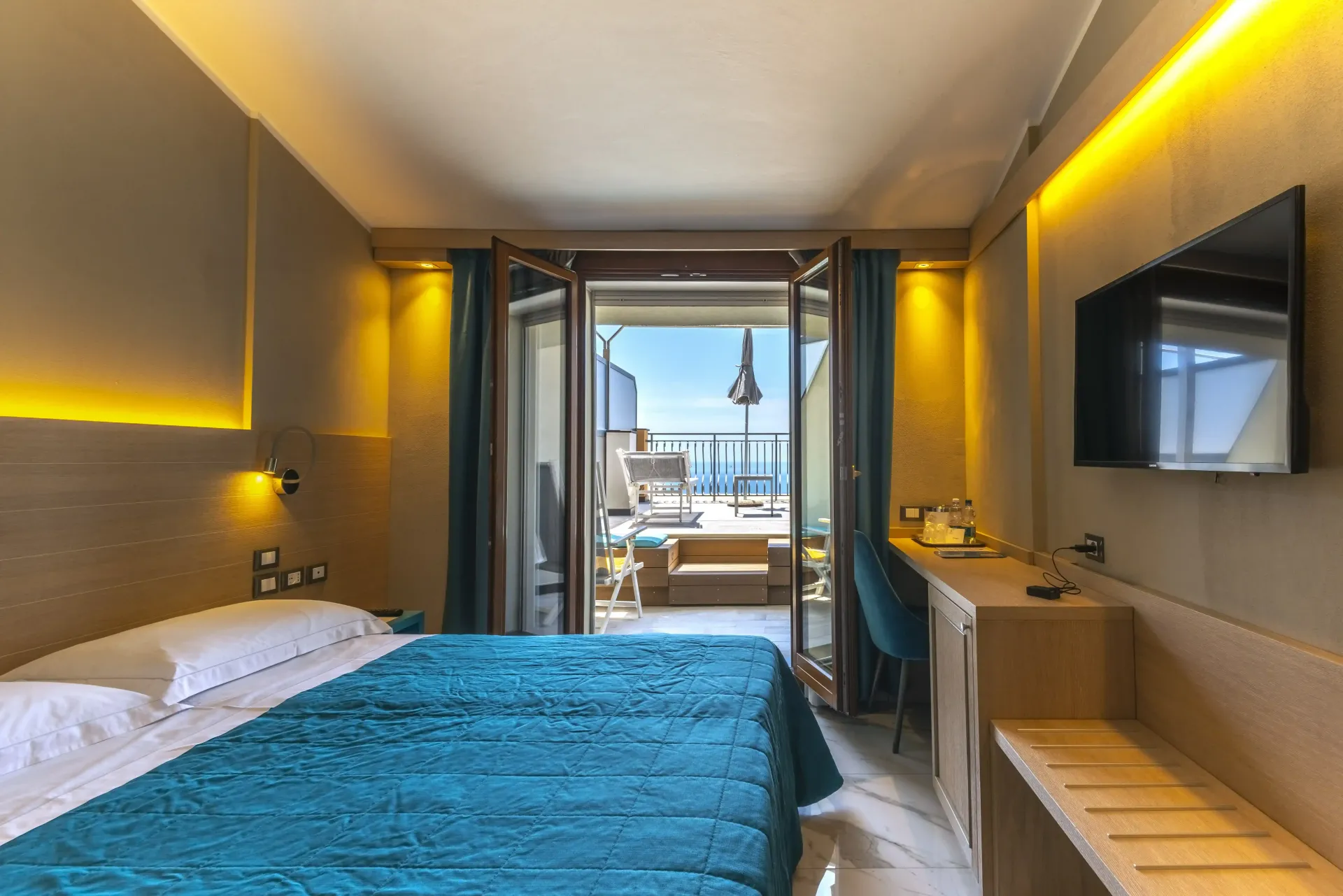Una camera d'albergo con un letto grande e una TV a schermo piatto