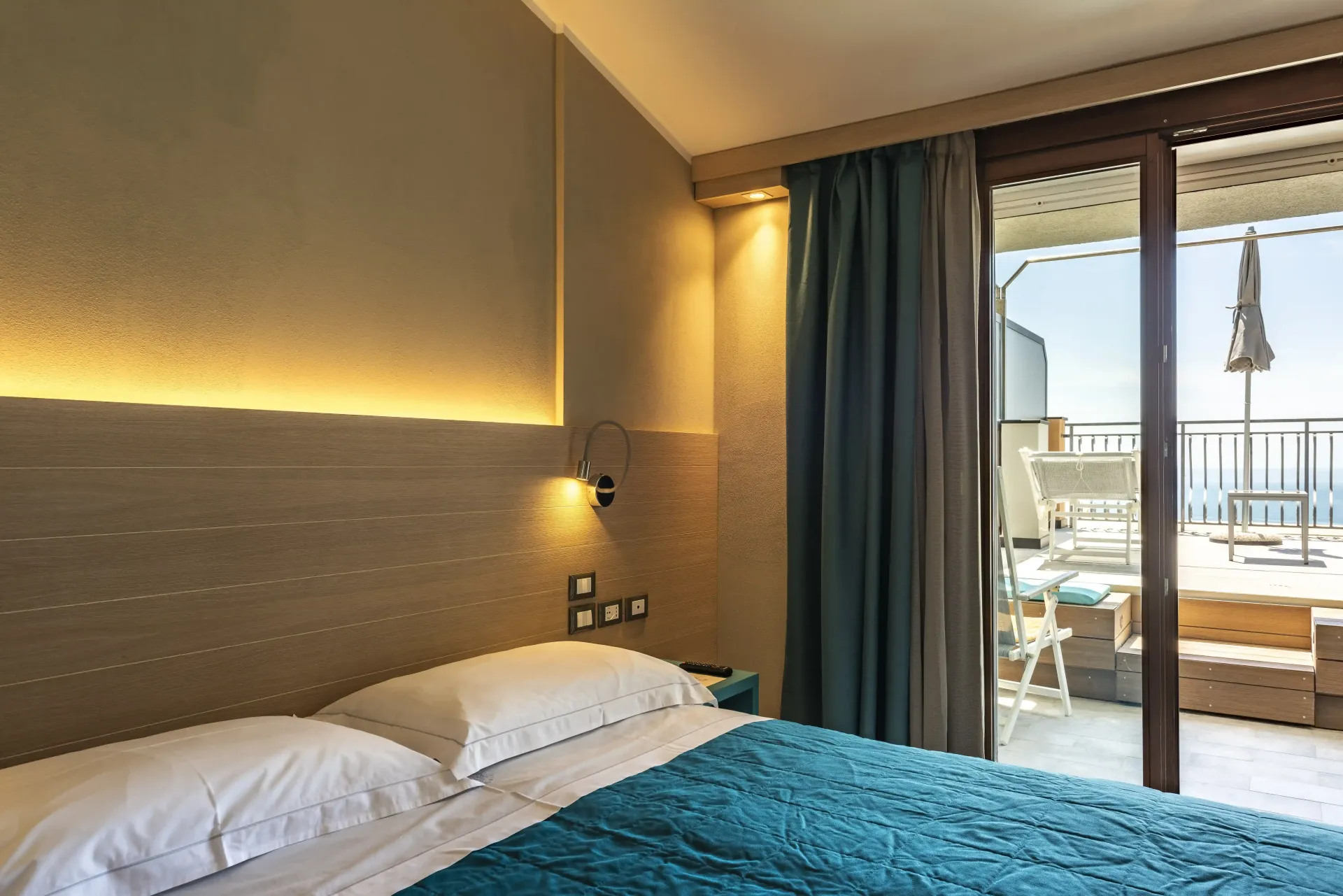 Una camera d'albergo con un letto e una porta scorrevole in vetro