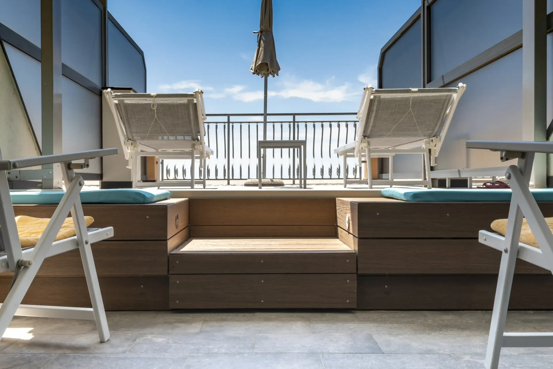 Un balcone con qualche sedia e un tavolo