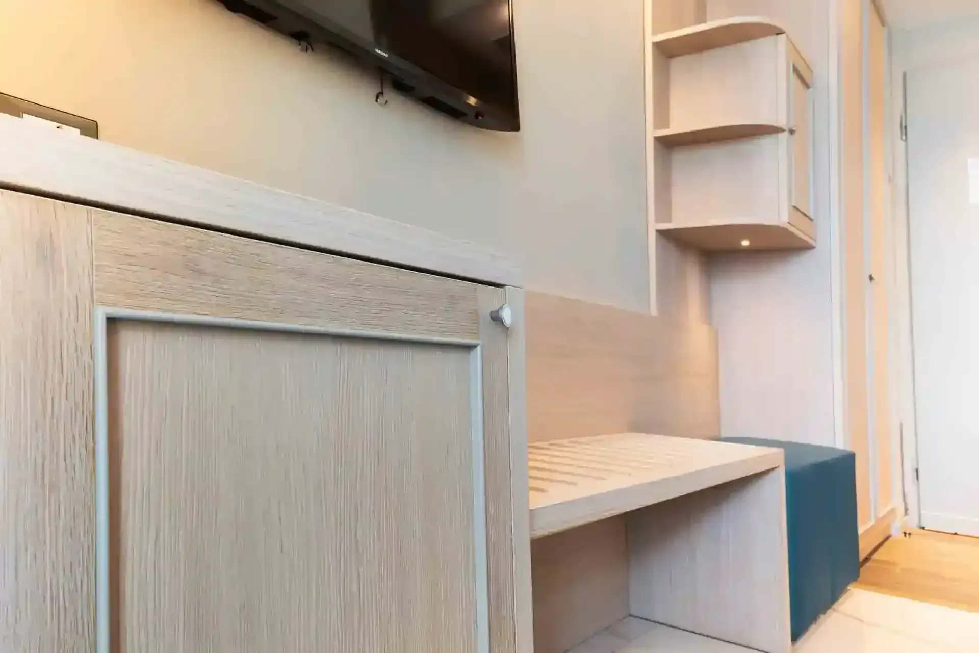 Una camera d'albergo con una tv a schermo piatto sul muro