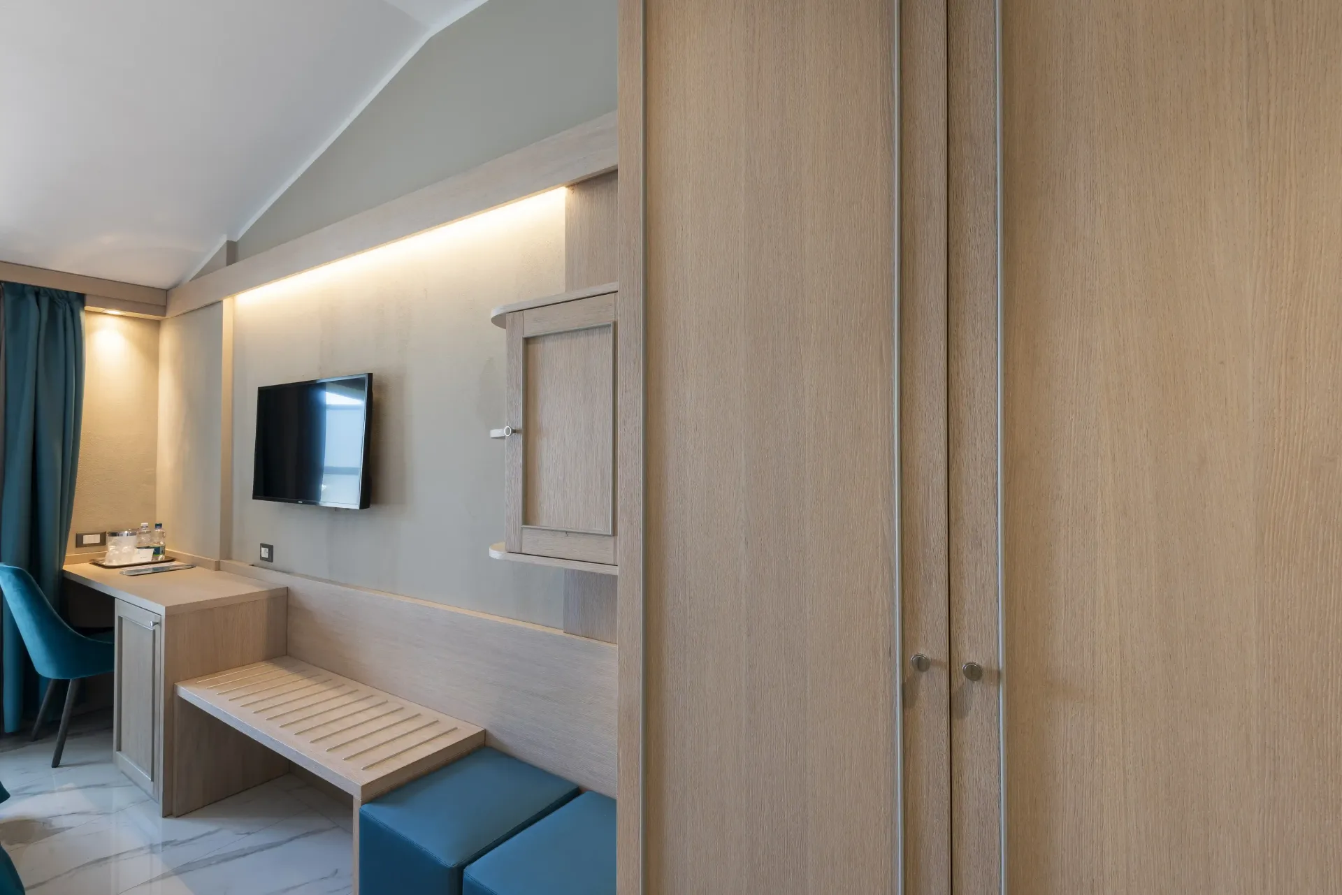 Una camera d'albergo con una tv a schermo piatto sul muro